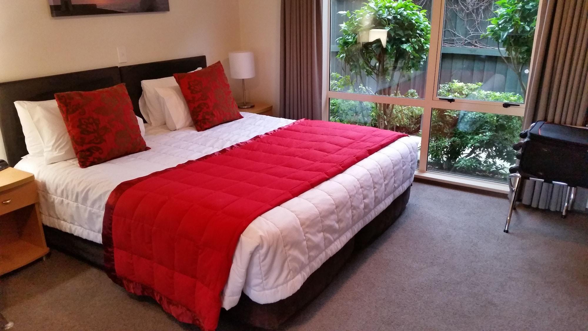 Colombo In The City Christchurch Exterior photo A bed with a red throw